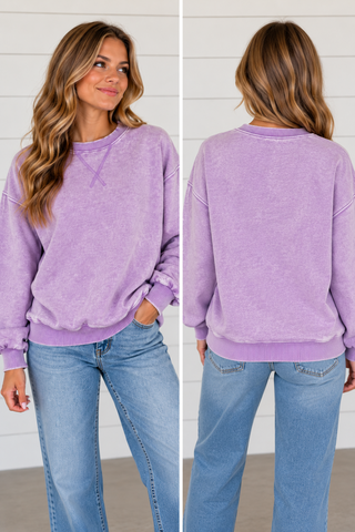 Woman wearing Lavender Skies washed lavender crewneck sweatshirt with light wash jeans