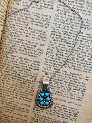 Turquoise cluster sterling silver necklace featuring six round turquoise stones with detailed Western silverwork.