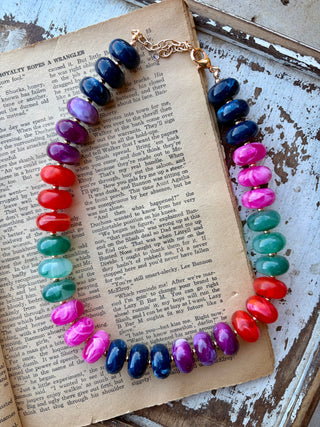 Chunky multicolor necklace with glossy navy, purple, pink, red, and teal beads, gold-tone spacers, and an extender chain.