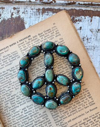 Turquoise peace sign statement belt buckle featuring multiple turquoise stones set in detailed alloy.