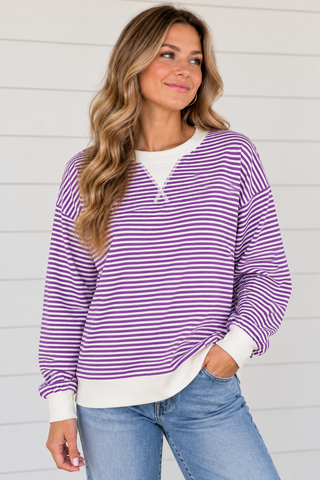 Woman wearing Purple Haze violet and white striped sweatshirt with white trim and light wash jeans