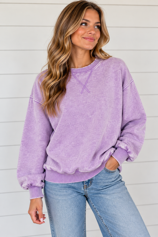Woman wearing Lavender Skies washed lavender crewneck sweatshirt with light wash jeans