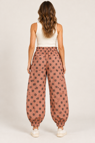     Back view of dusty rose polka dot balloon pants with two patch pockets and elastic ankle cuffs.