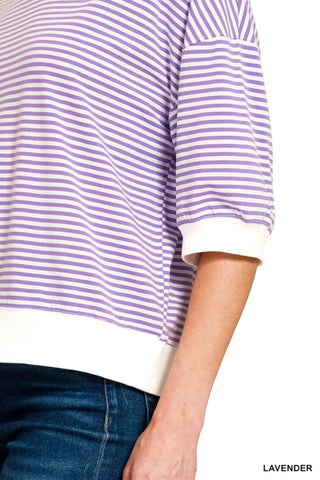Women’s lavender and white striped oversized knit top with a crew neckline, drop shoulders, elbow-length sleeves, and white ribbed trim at the neckline, cuffs, and hem. Relaxed fit with a modern casual style.