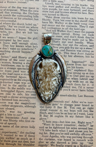 Western buffalo pendant featuring a carved water buffalo bone buffalo, genuine turquoise stone, and detailed silver-tone setting.