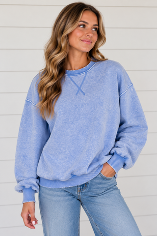Woman wearing Blue Skies cornflower blue washed sweatshirt with light wash jeans
