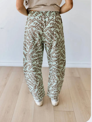 Dusty blue Yeehaw Howdy barrel pants with brown Western word print, drawstring waist and relaxed fit.