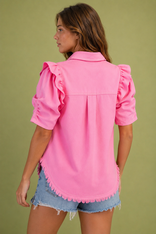     Back view of pink ruffle sleeve button-up top featuring a relaxed fit, back pleat and frayed curved hem.