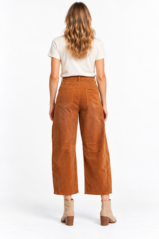 Back view of rust-brown corduroy barrel pants showing patch pockets, belt loops, and seam detailing.