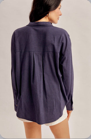 Navy pinstripe oversized button-up shirt with long sleeves, classic collar, and relaxed fit.