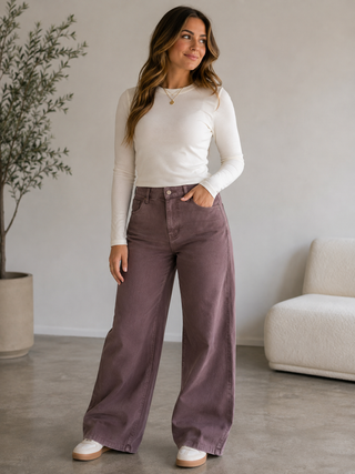 Model wearing Dusty Trails dusty mauve high-rise wide leg pants with an ivory fitted top.