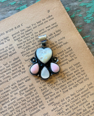 Mother of pearl heart pendant with two pink conch teardrops, a mother of pearl teardrop, and floral details in a silver-tone alloy setting.