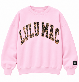 Light pink Lulu Mac crewneck sweatshirt with arched leopard-print lettering, ribbed cuffs and hem, and a black sleeve logo patch on a white background.
