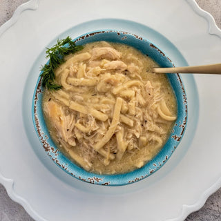 Crockstar Homestyle Chicken & Noodles with shredded chicken and thick noodles in creamy broth, served in a turquoise bowl.