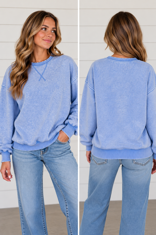 Woman wearing Blue Skies cornflower blue washed sweatshirt with light wash jeans