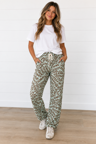 Dusty blue Yeehaw Howdy barrel pants with brown Western word print, drawstring waist and relaxed fit.