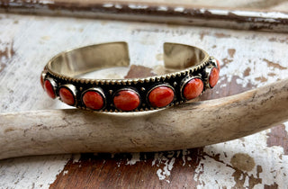 Red spiny oyster stone cuff bracelet set in alloy with seven oval stones and an antiqued finish.