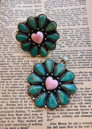 Matching turquoise statement ring and pendant featuring teardrop-shaped turquoise stones arranged in a flower design around a pink heart-shaped center stone, with ornate silver-tone detailing.