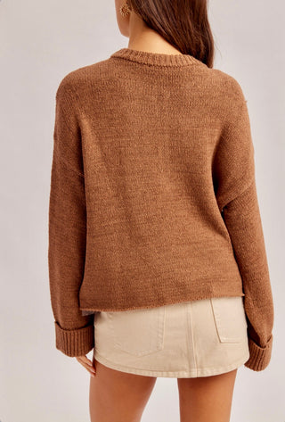 Brown cable knit button-front cardigan with open-knit detailing and relaxed fit.