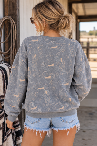 Model wearing washed gray western print sweatshirt with cowboy hats boots moons and stars