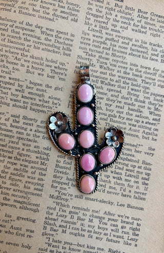 Pink conch cactus pendant featuring seven oval pink conch shell stones with floral accents and Southwestern rope detailing.