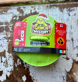 Grinch Mystery Squishy toy in green and red holiday packaging with a mystery design and a chance to find the rare Goldmine Grinch.