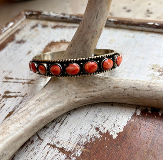 Red spiny oyster stone cuff bracelet set in alloy with seven oval stones and an antiqued finish.