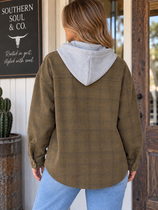 Back view of the Timberline olive-brown plaid hooded shacket featuring a gray hood, relaxed fit, and curved hem.