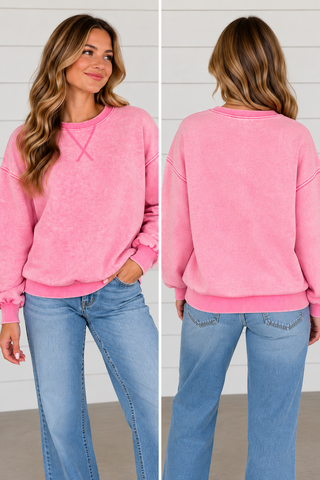 Woman wearing Pink Skies candy pink washed sweatshirt with light wash jeans