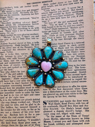 Statement pendant featuring turquoise stones arranged in a flower design around a pink heart-shaped center stone, with detailed silver-tone metalwork.