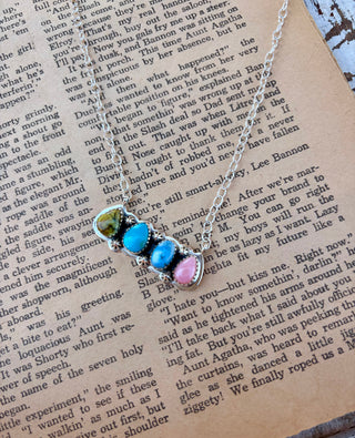 19-inch sterling silver necklace with turquoise, pink conch, and palomino stones in a decorative four-stone setting.