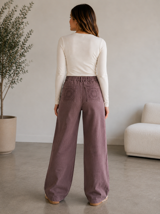 Back view of Dusty Trails mauve wide leg pants featuring an elasticized waistband and crochet-style statement pockets.