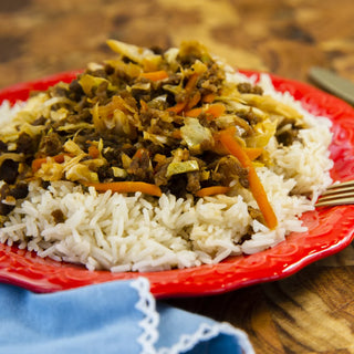 Crockstar Egg Roll in a Bowl with ground meat, cabbage, and carrots served over white rice on a red plate.