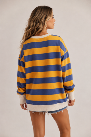 Back view of blue and golden yellow striped oversized sweatshirt with cream trim